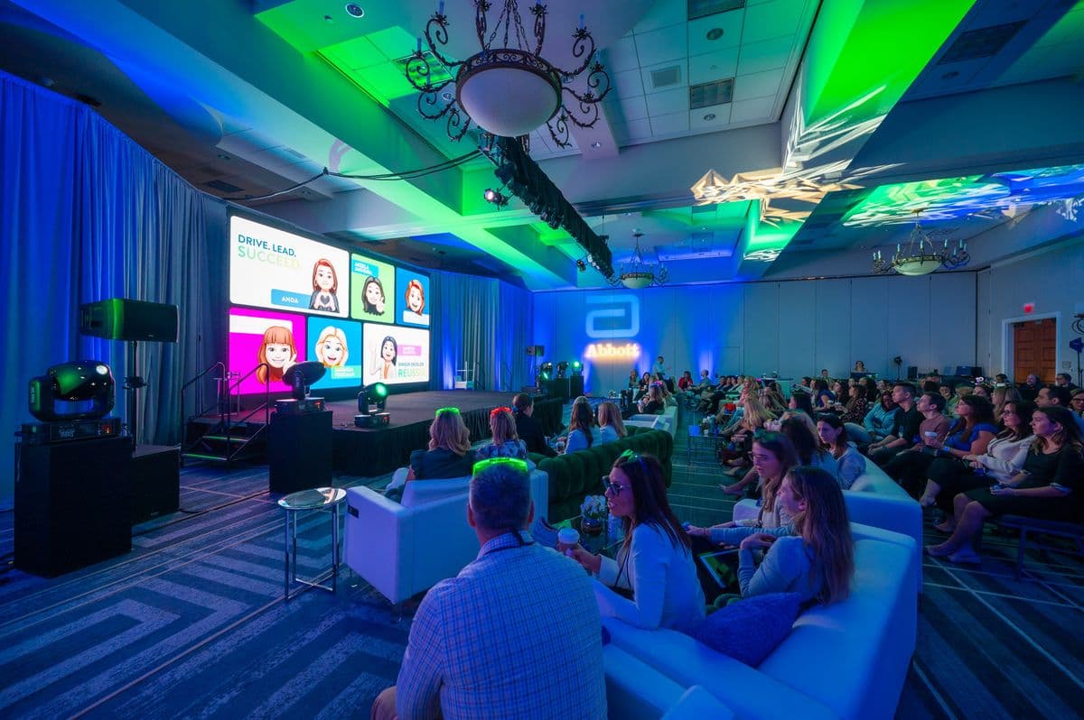 Corporate conference session with a branded stage and audience seating
