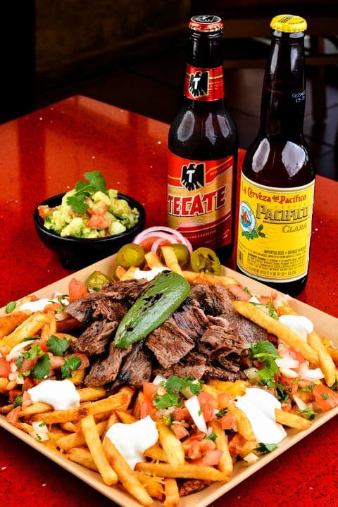 Carne asada fries with guacamole and Mexican beers