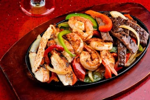Sizzling fajita platter on a cast iron skillet