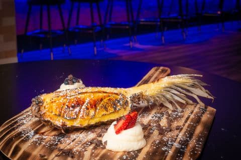 Charred pineapple dessert with whipped cream and berries