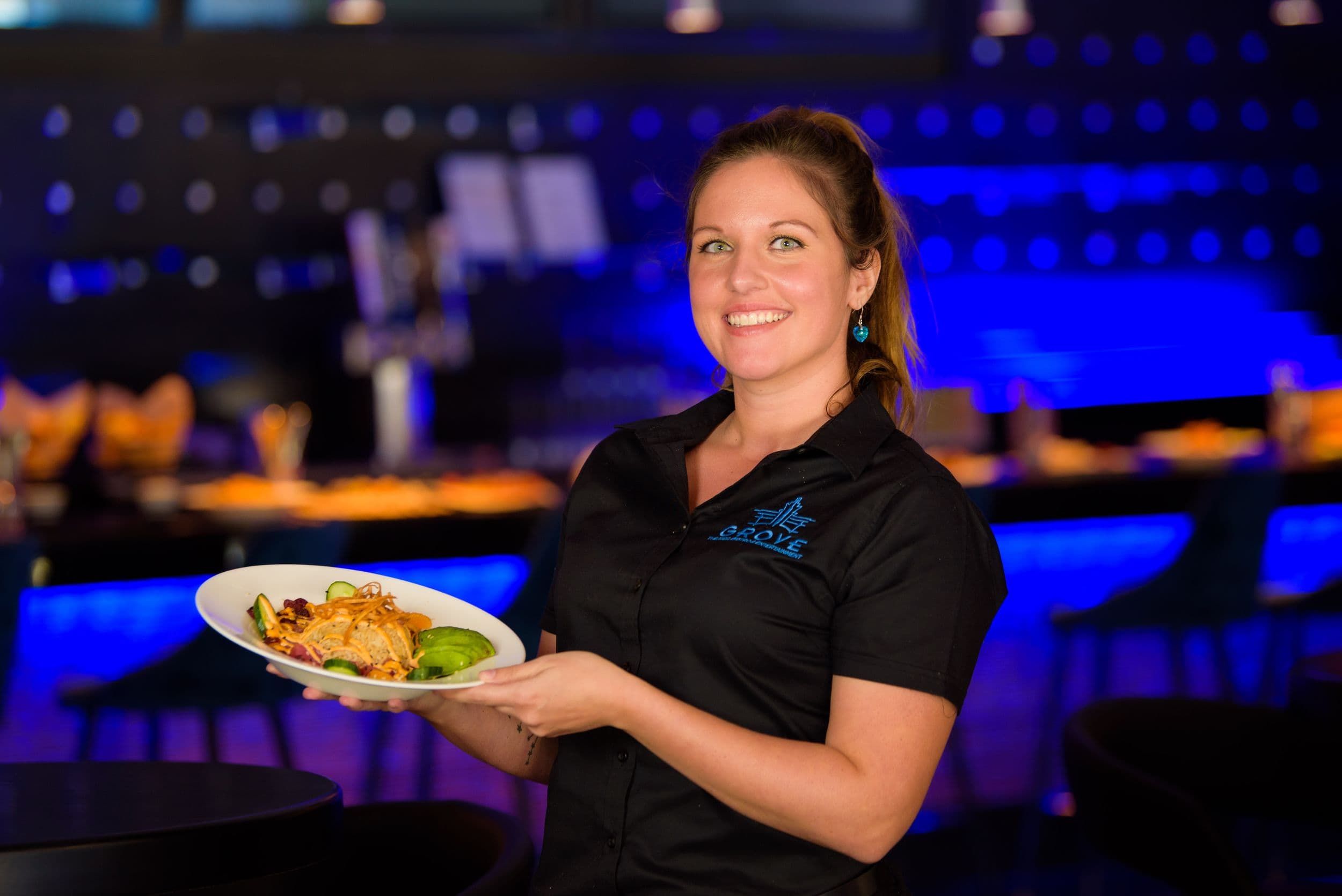 Server presenting a fresh salad at The Grove