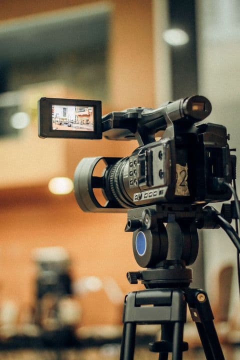 Video camera on a tripod capturing an interior room for a 3D property tour