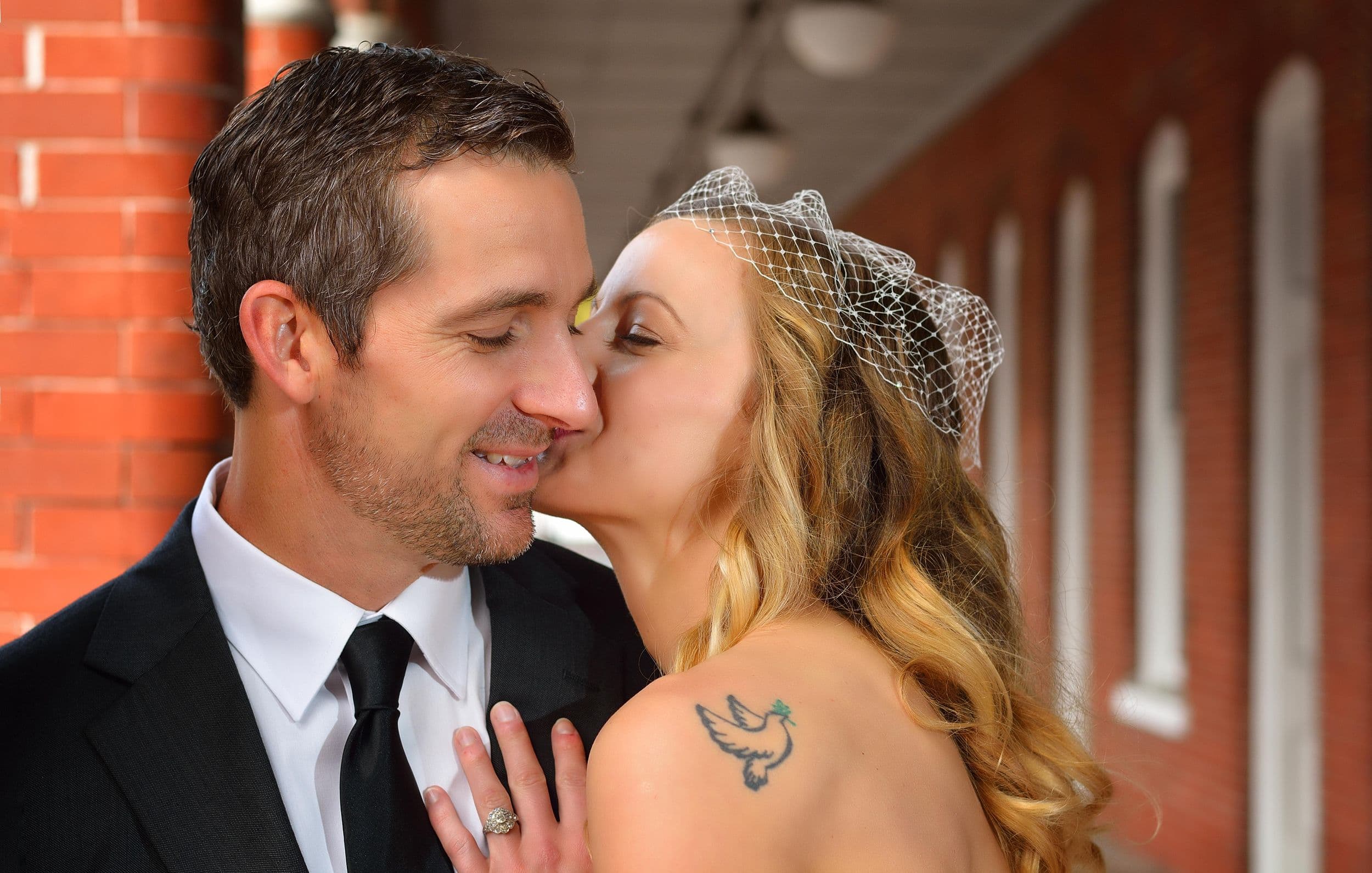 Couple kissing and displaying ring in Ybor City