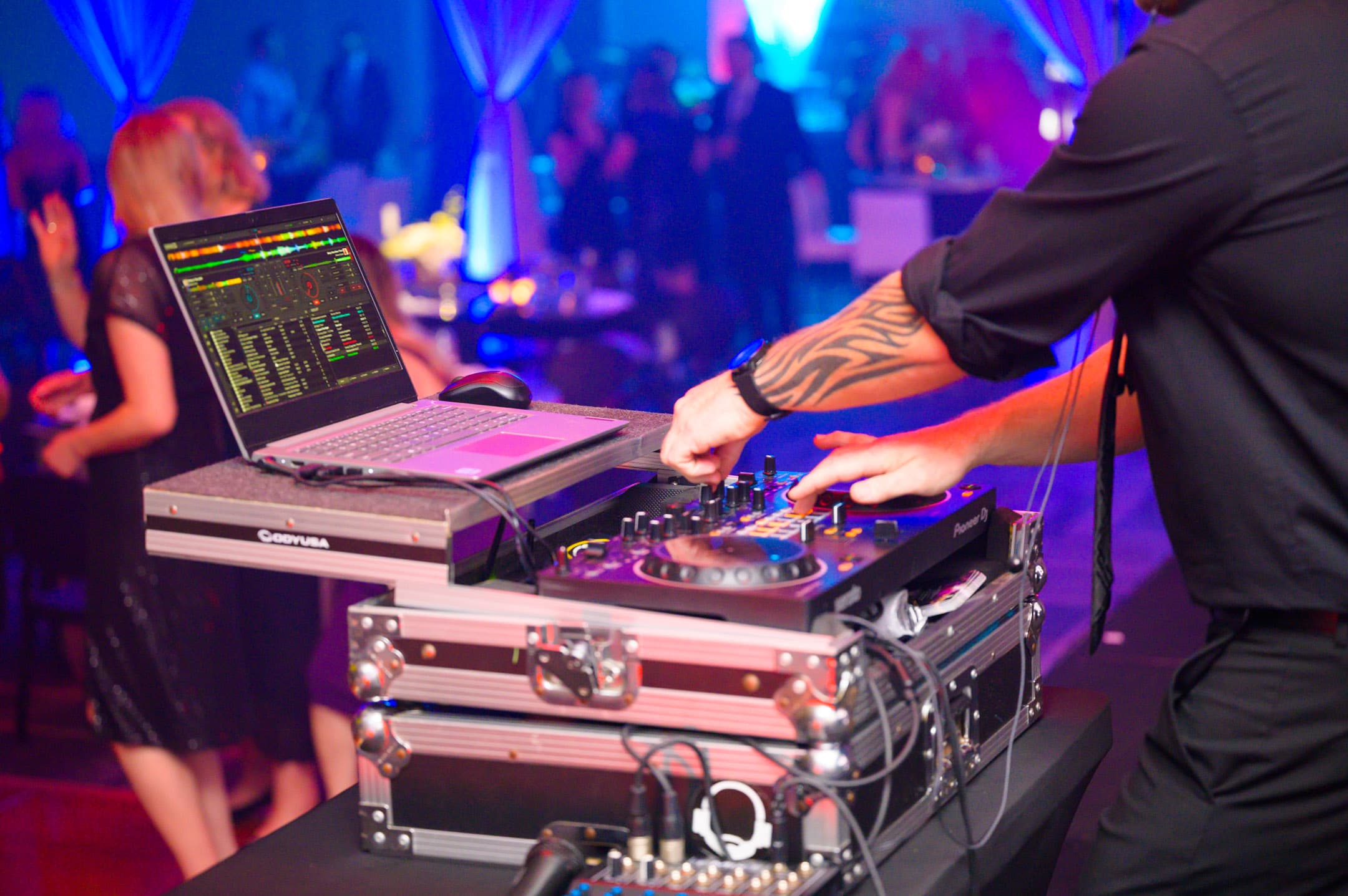 DJ performing for guests on the dance floor at an evening reception