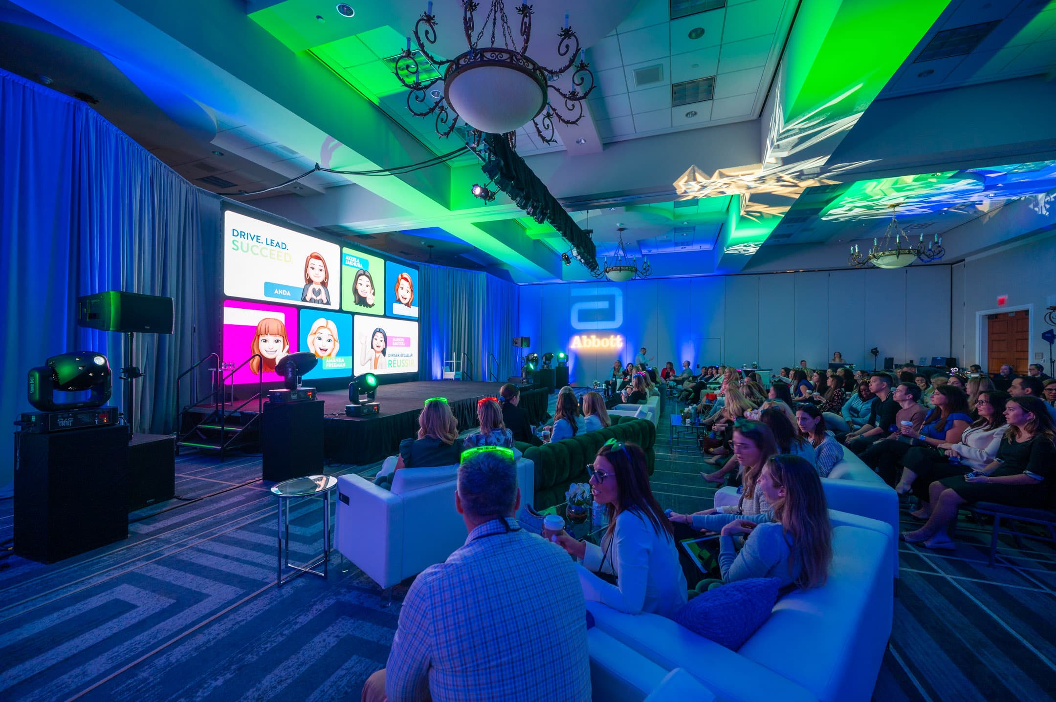Corporate conference session with a branded stage and audience seating